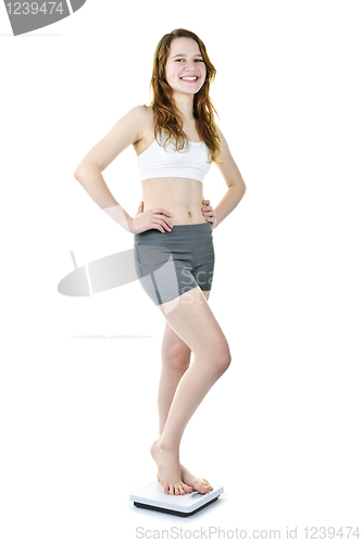 Image of Happy young girl standing on bathroom scale