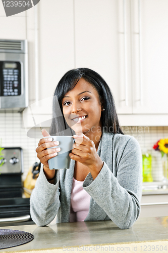 Image of Woman in kitchen with coffee cup