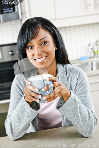 Image of Woman in kitchen with coffee cup