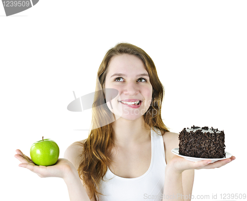 Image of Young girl holding apple and cake