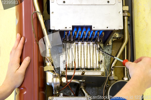 Image of hands of a plumber repairing a gas heating 