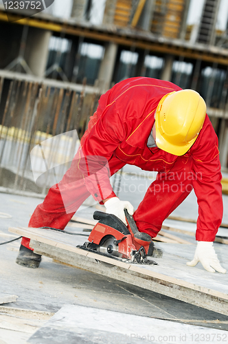 Image of cutting construction wood board with grinder saw
