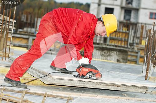 Image of cutting construction wood board with grinder saw