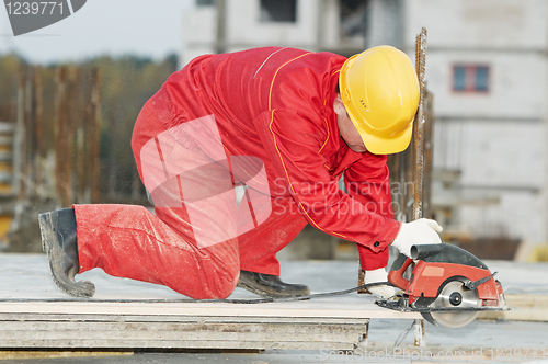 Image of cutting construction wood board with grinder saw