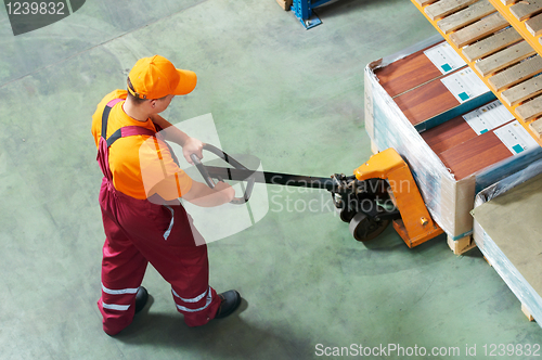 Image of worker with fork pallet truck