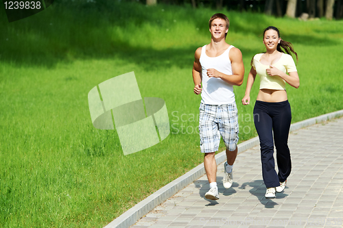 Image of Young man and woman jogging outdoors