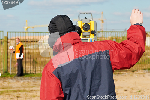 Image of surveyor works with theodolite tacheometer