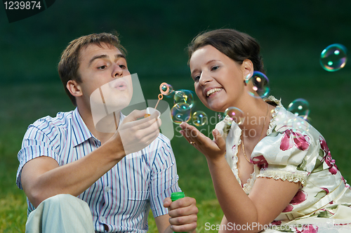 Image of happy couple blowing soap bubbles