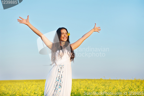 Image of girl with hands up at summer field