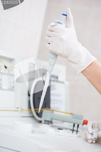 Image of female doctor hand with dropper