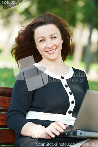 Image of female boss with computer outdoors