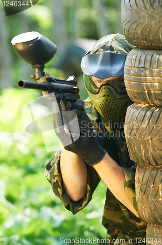 Image of paintball player under cover
