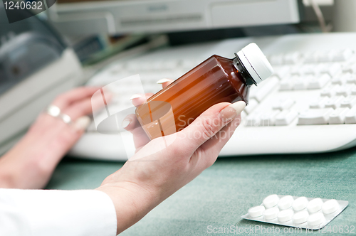 Image of closeup hand of chemist with drug