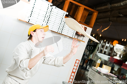 Image of Pizza baker juggling with dough