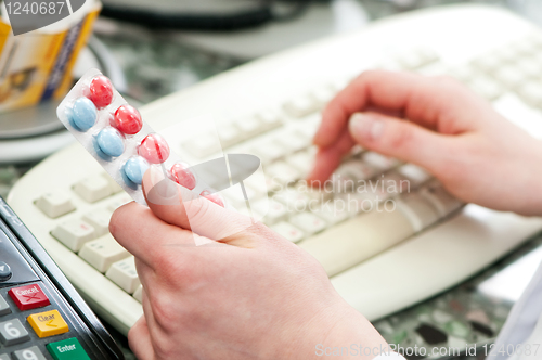 Image of closeup hand of chemist with drug