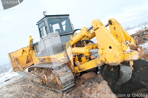 Image of bulldozer loader at winter frozen soil works