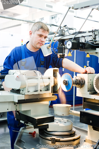 Image of worker at machine tool operating