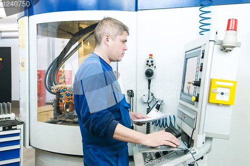 Image of worker operating CNC machine center