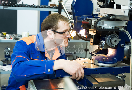 Image of worker at machine tool operating