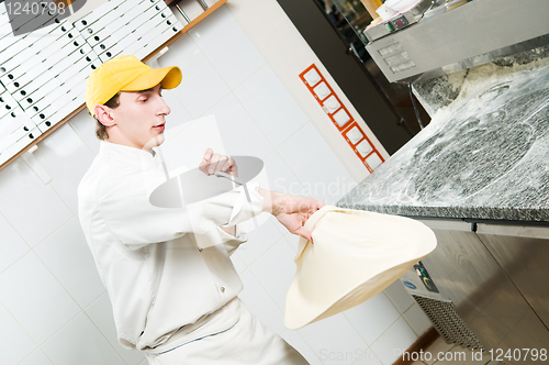 Image of Pizza baker juggling with dough