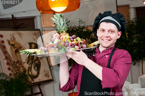 Image of Cheerful chef cook with fruits
