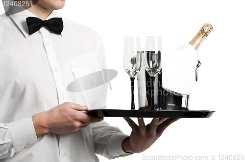 Image of Waiter hands champagne in bucket and stemware on tray