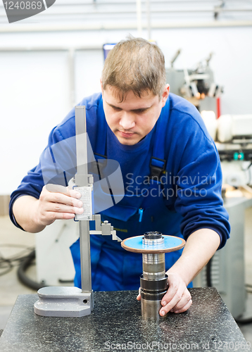 Image of worker measuring cutting tool