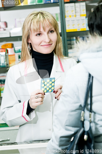 Image of cheerful pharmacist and client in drugstore