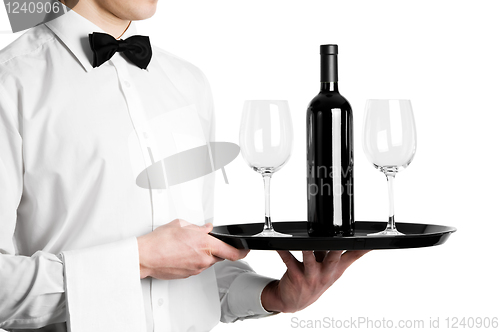 Image of Waiter hands with wine bottle and stemware on tray