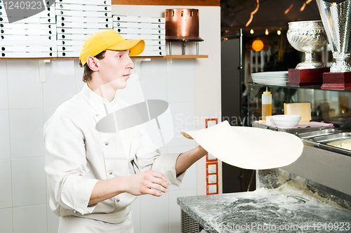 Image of Pizza baker juggling with dough