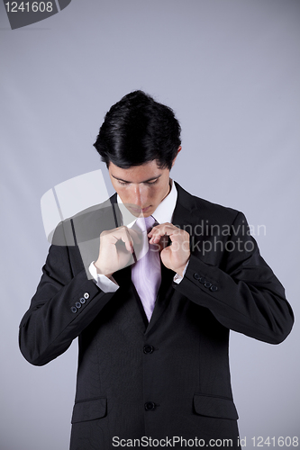 Image of Businessman tying his necktie
