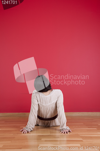 Image of Woman looking to a red wall