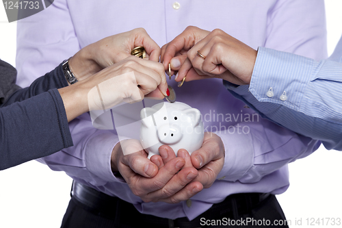 Image of Hands inserting money in the piggybank