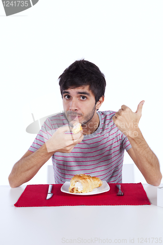 Image of Young man eating a cake