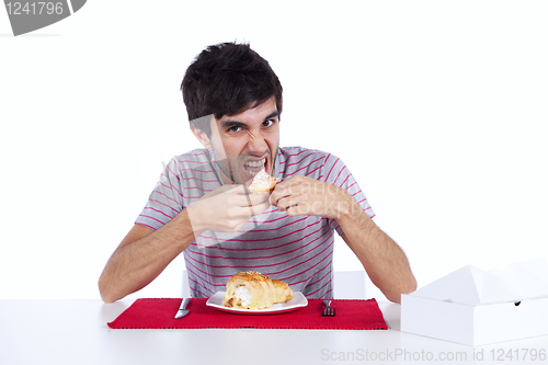 Image of Young man eating a cake