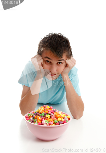 Image of Boy relaxes with bowl of snack food