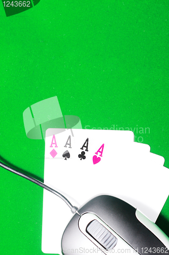 Image of An online gaming concept with computer mouse, four aces and green felt