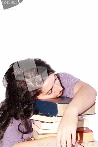 Image of Young beautiful woman sleeping with books in a white background