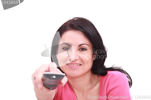 Image of Joyful brunnete woman indoors changing TV channels 