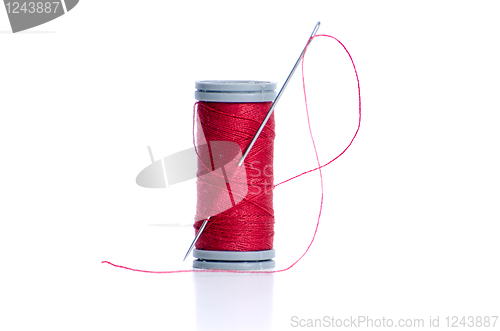 Image of Red thread bobbin and needle 