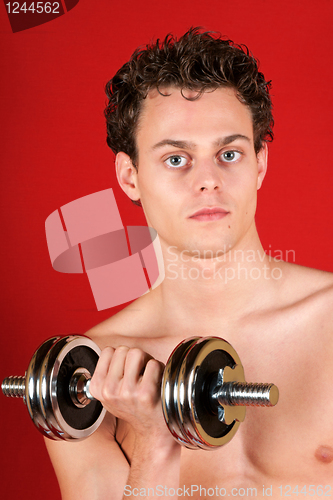 Image of Young man training with dumbbell