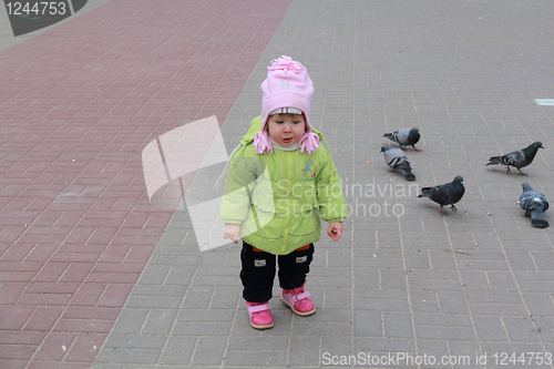 Image of girl walks in park and feeds birds