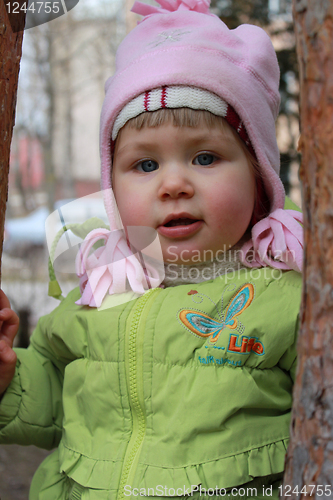 Image of girl hides behind a tree