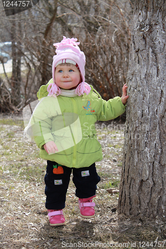 Image of girl hides behind a tree