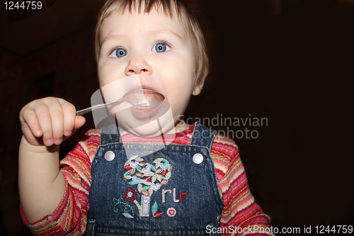 Image of girl licks a silver spoon