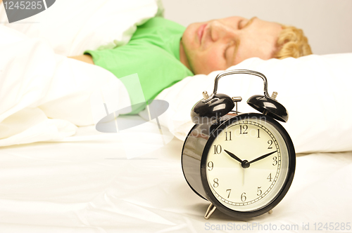 Image of Serene man lying on his bed before being woken up   