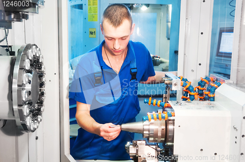 Image of worker operating CNC machine center