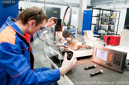 Image of laborer checking tool with optical device