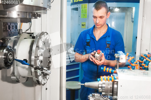 Image of worker operating CNC machine center