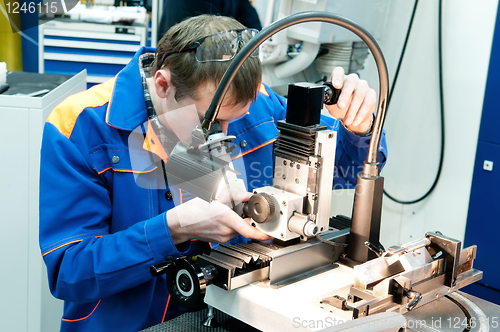 Image of worker checking tool with optical device